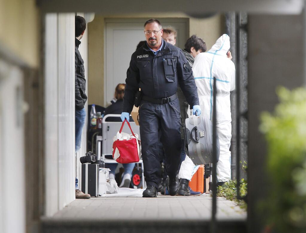 German police officers secure evidence in front of an apartment in Oberursel, Germany, Thursday, April 30, 2015. Chief of police for western Hesse state Stefan Mueller said authorities found a pipe bomb, 100 rounds of ammunition, parts of an assault rifle and a chemical that can be used to build a bomb during a raid overnight in the town of Oberursel. (AP Photo/Michael Probst)