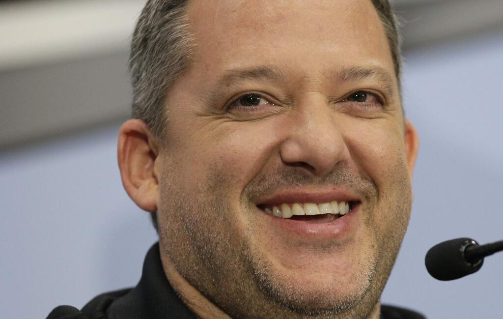 Tony Stewart smiles as he answers a question during a news conference to announce his retirement from driving NASCAR Sprint Cup series racing after the 2016 season at Stewart-Haas Racing's headquarters in Kannapolis, N.C., Wednesday, Sept. 30, 2015. (AP Photo/Chuck Burton)