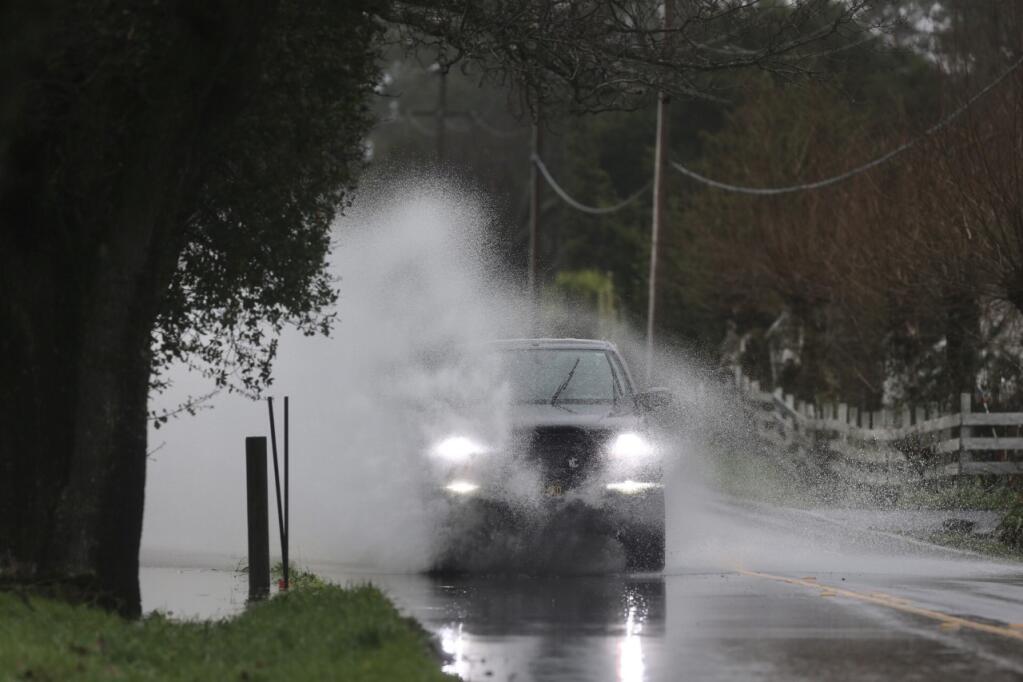 A pickup truck drives through standing water on Llano Road in Santa Rosa, Wed. Jan. 11, 2023. (Beth Schlanker/The Press Democrat)