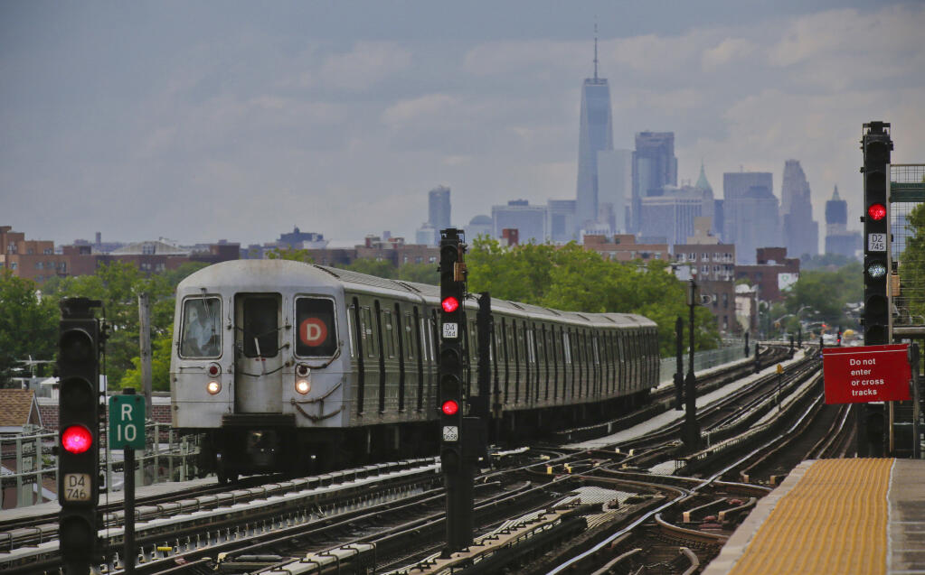 FILE - A subway approaches an above ground station in the Brooklyn borough of New York with the New York City skyline in the background, June 21, 2017. The transit authority that runs subways, commuter trains and buses in New York City is giving up on a system that sent automated alerts about service disruptions through Twitter. The Metropolitan Transportation Authority decided to stop using Twitter for service alerts Thursday, April 27, 2023. (AP Photo/Bebeto Matthews, File)