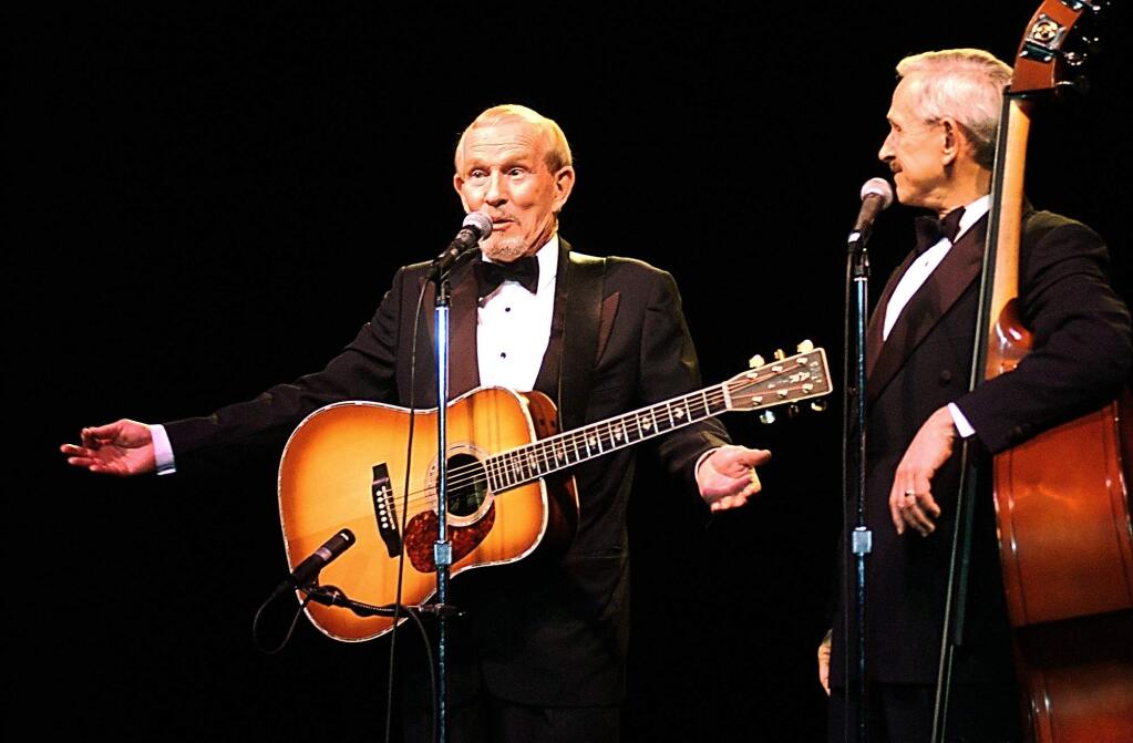 Tommy Smothers, left, and his brother Dick Smothers entertain at Luther Burbank Center in Santa Rosa, Feb. 25, 2004. After Tommy spun a tale of how he piloted Dick on a biplane tour above the Wine Country, and Dick asked “why did you lie” (since Tommy isn't a pilot), Tommy replied: “national policy.” (The Press Democrat file)