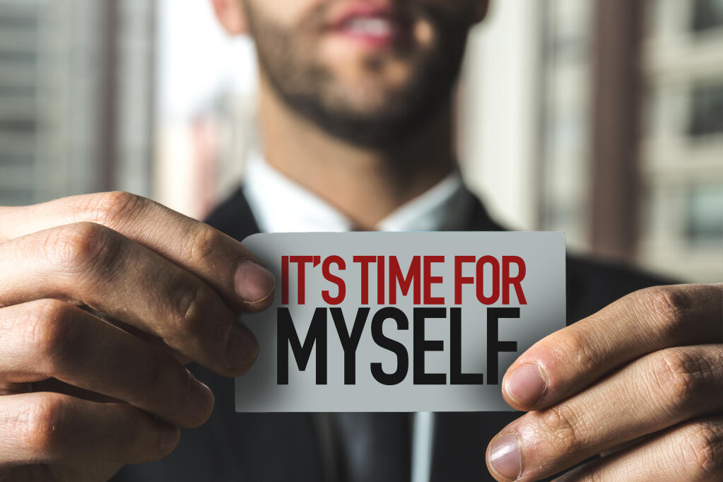 A businessman in a suit with his face half-seen holds a card that says, "It's time for myself."