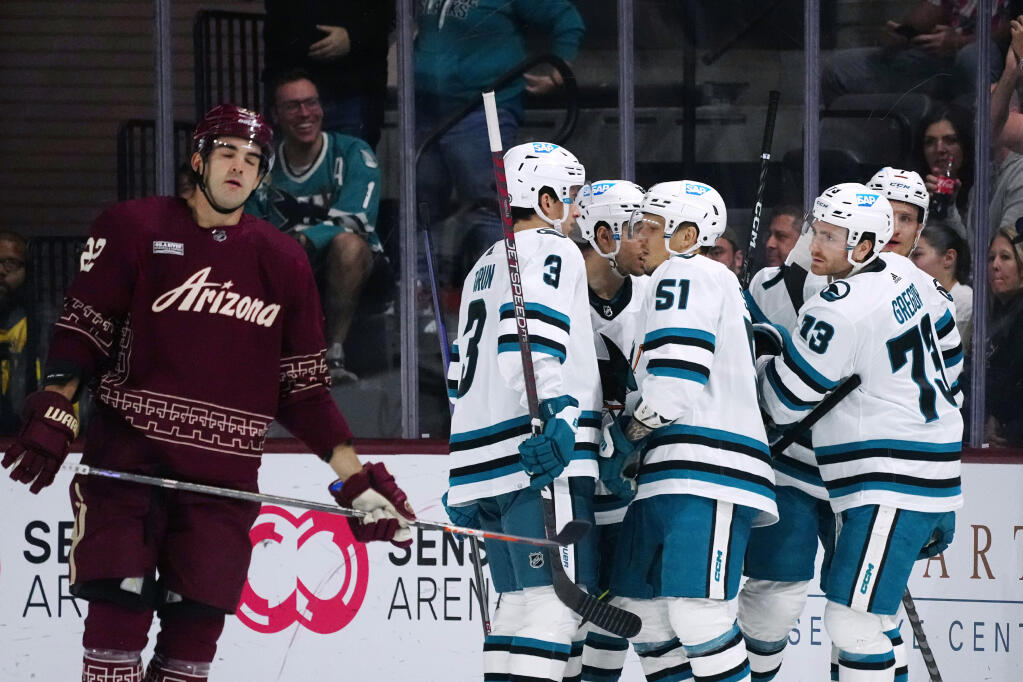 San Jose Sharks center Noah Gregor celebrates his goal with defensemen Radim Simek and Henry Thrun, right wing Kevin Labanc, third from left, and center Nico Sturm, back right, as Coyotes center Jack McBain skates past during the first period Saturday, April 1, 2023, in Tempe, Arizona. (Ross D. Franklin / ASSOCIATED PRESS)
