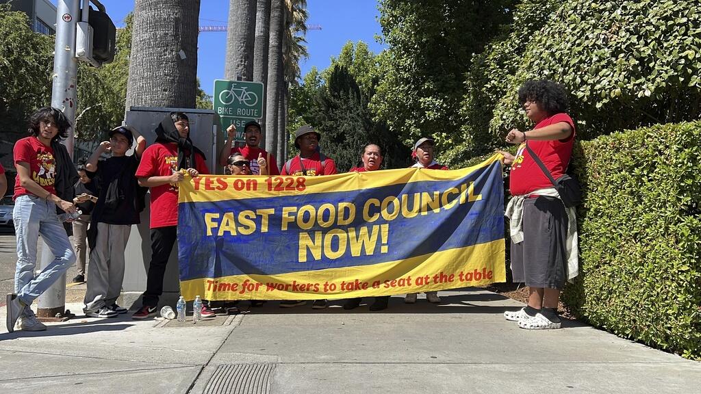 Fast-food workers and union activists demonstrate outside the state Capitol in support of legislation to increase wages. (TERRY CHEA / Associated Press)