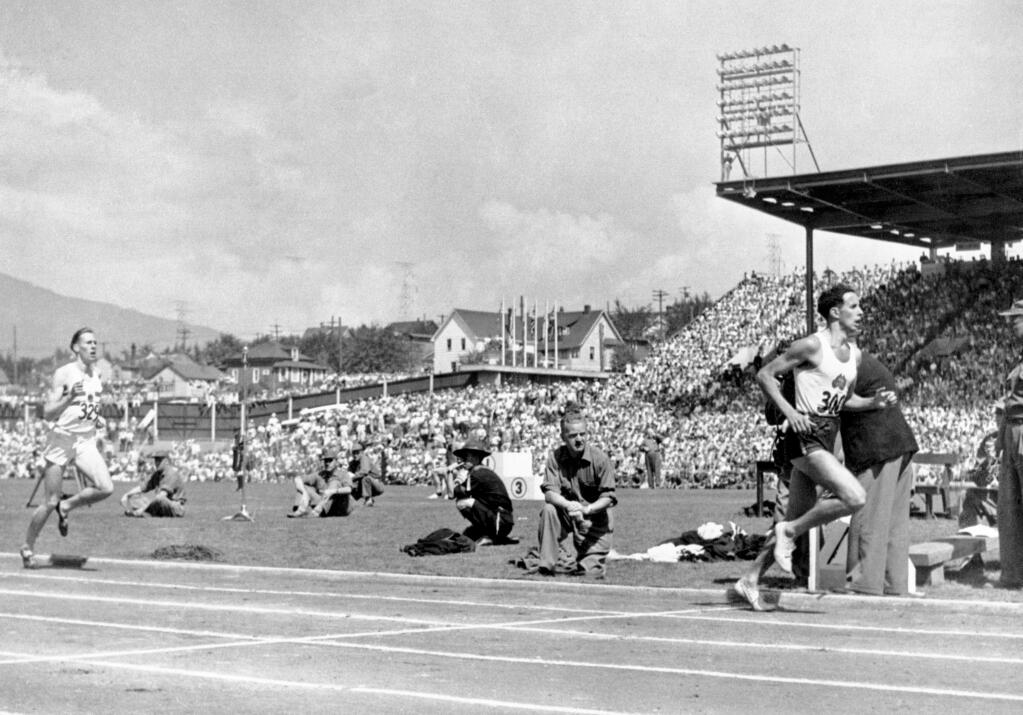 FILE - John Landy of Australia, right, leads Roger Bannister of England at the half-way mark during the one mile race at the Empire Games, now known as the Commonwealth Games, in Vancouver, Canada, on Aug. 7, 1954. Landy, an Australian middle-distance runner who dueled with Roger Bannister to be the first person to run a four-minute mile, has died, his family said Saturday, Feb. 26, 2022. He was 91. (AP Photo, File)
