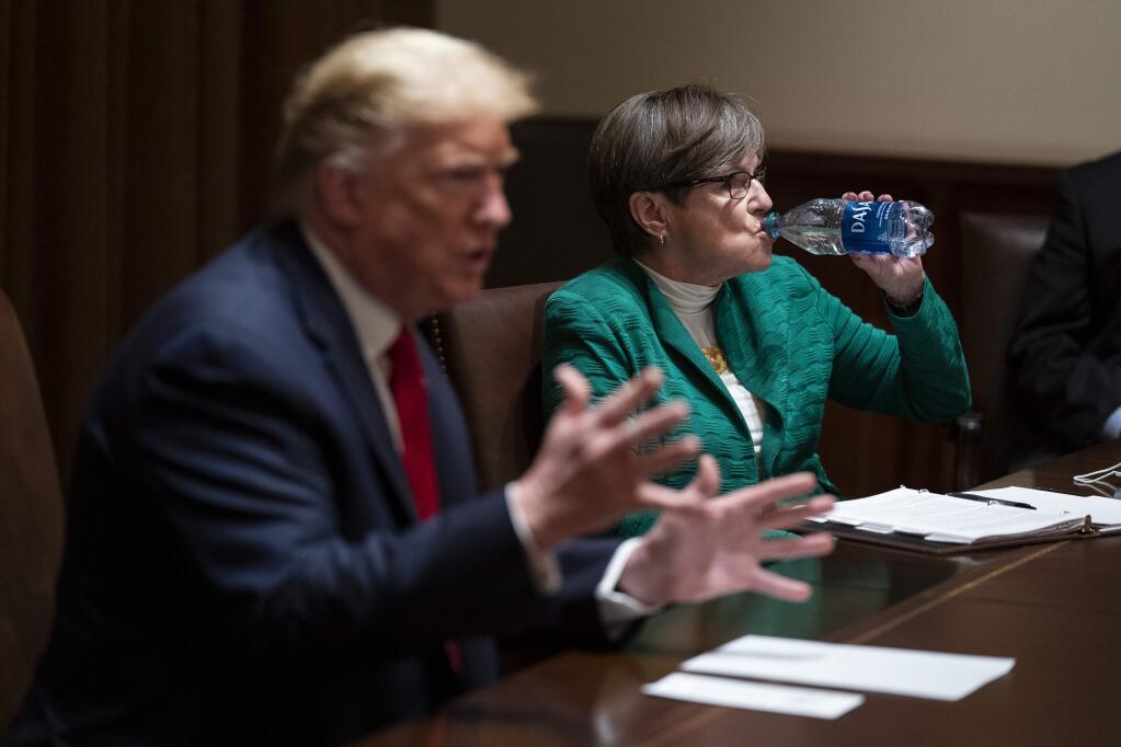 Kansas Gov. Laura Kelly listens as President Donald Trump speaks during a meeting in the Cabinet Room of the White House, Wednesday, May 20, 2020, in Washington. (AP Photo/Evan Vucci)