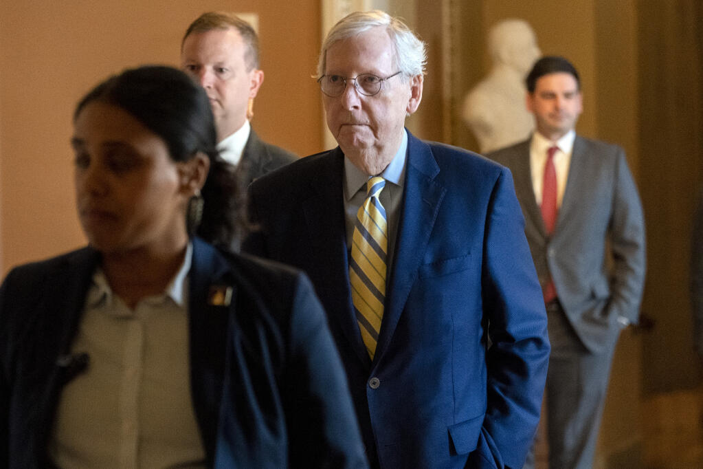 Senate Minority Leader Mitch McConnell, R-Ky., center, walks to the Senate Chamber, Monday, April 17, 2023, on Capitol Hill in Washington, after almost six weeks away after a fall at a Washington-area hotel and extended treatment for a concussion. (AP Photo/Jacquelyn Martin)