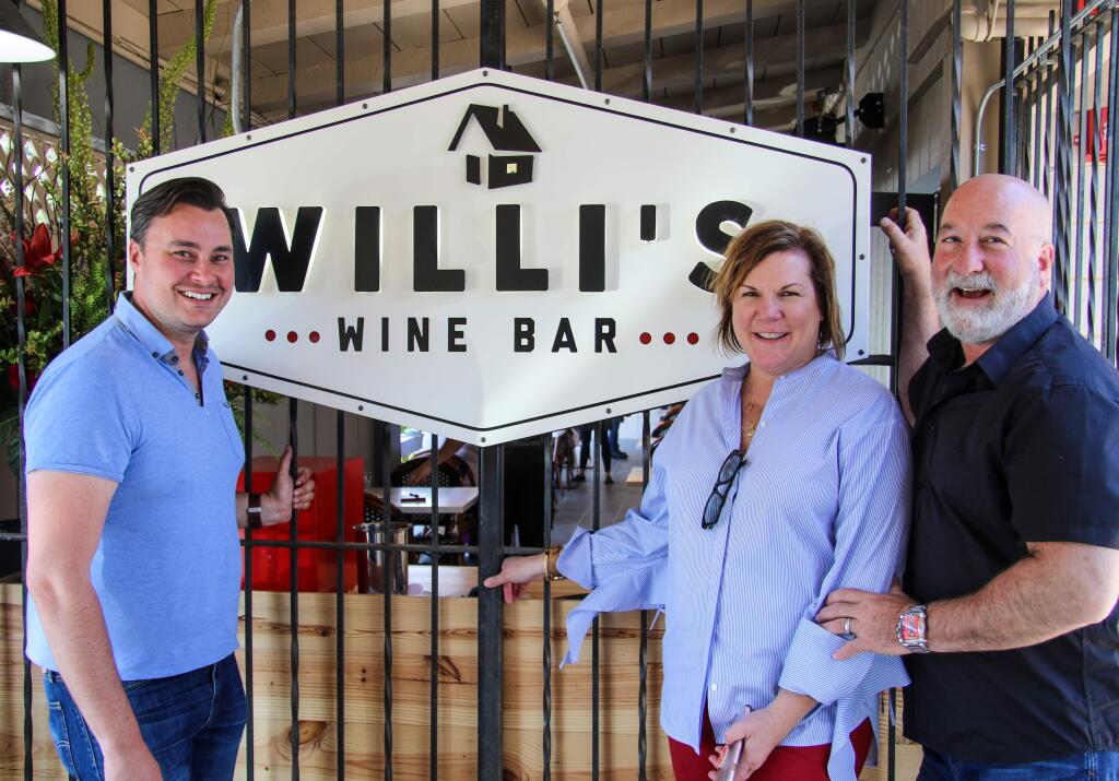 Willi's Wine Bar employee Landon McPherson, left, celebrates its grand opening with owners Terri and Mark Stark on Thursday, May 30, 2019. (HEATHER IRWIN/PD)