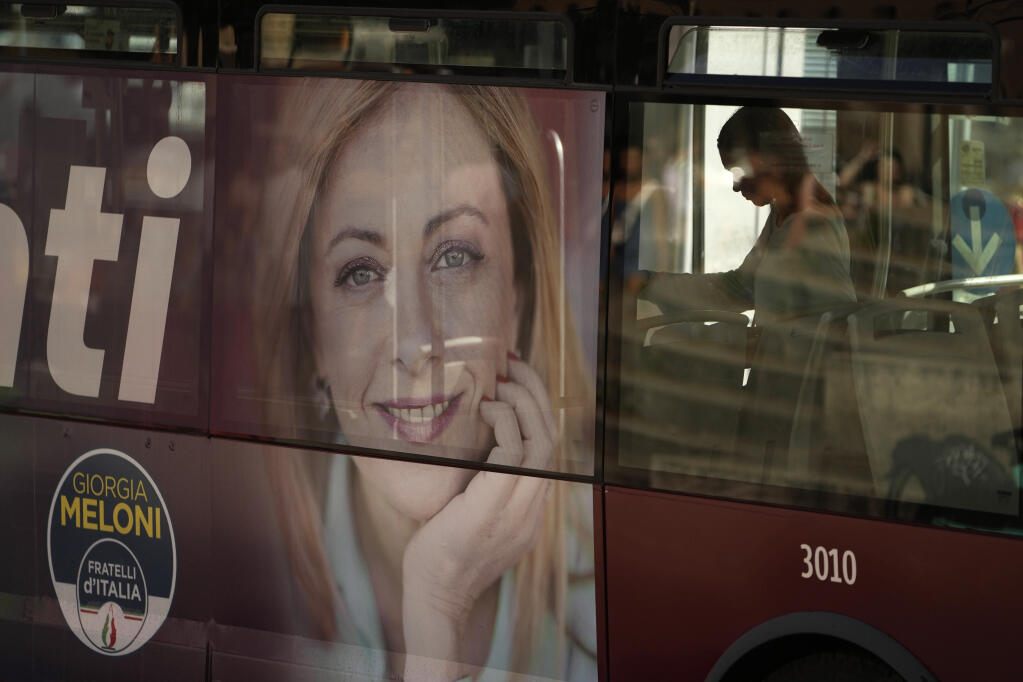 A poster of Italy's candidate premier Giorgia Meloni is seen on the side of a bus, in Rome, Friday, Sept. 16, 2022. (AP Photo/Alessandra Tarantino)