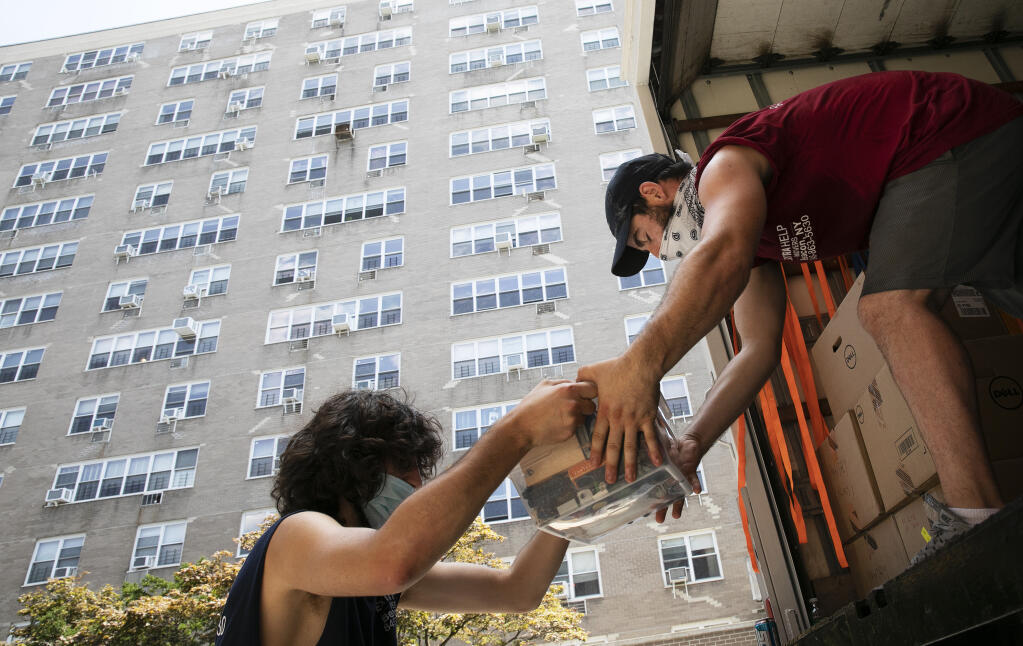 FILE - Jakob Howell, left, and Matt Brown load boxes belonging to Joyce and Anil Lilly into a moving truck, Tuesday, July 21, 2020, in The Bronx borough of New York. The number of former Californians who became new Texans dropped slightly last year, and some of that slack was picked up by Florida which saw its share of ex-Californians grow, according to new state-to-state migration figures released Thursday, Oct. 19, 2023. (AP Photo/Mark Lennihan, File)