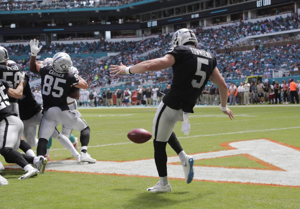 Oakland Raiders punter Johnny Townsend, right, punts the ball on fourth down during the first half against the Miami Dolphins, Sunday, Sept. 23, 2018 in Miami Gardens, Fla. (AP Photo/Lynne Sladky)