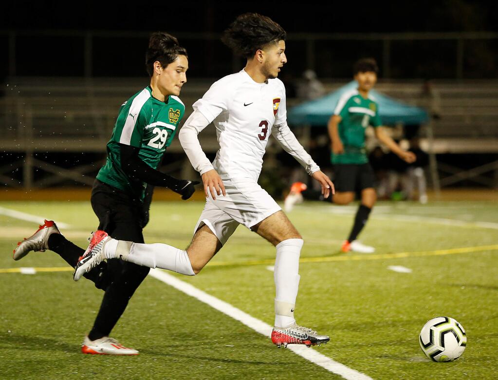 Piner's Alexis Dominguez, right, takes the ball downfield while pursued by Maria Carrillo's Antonio Serafini during the first half in Santa Rosa on Tuesday, January 21, 2020. (Alvin Jornada / The Press Democrat)