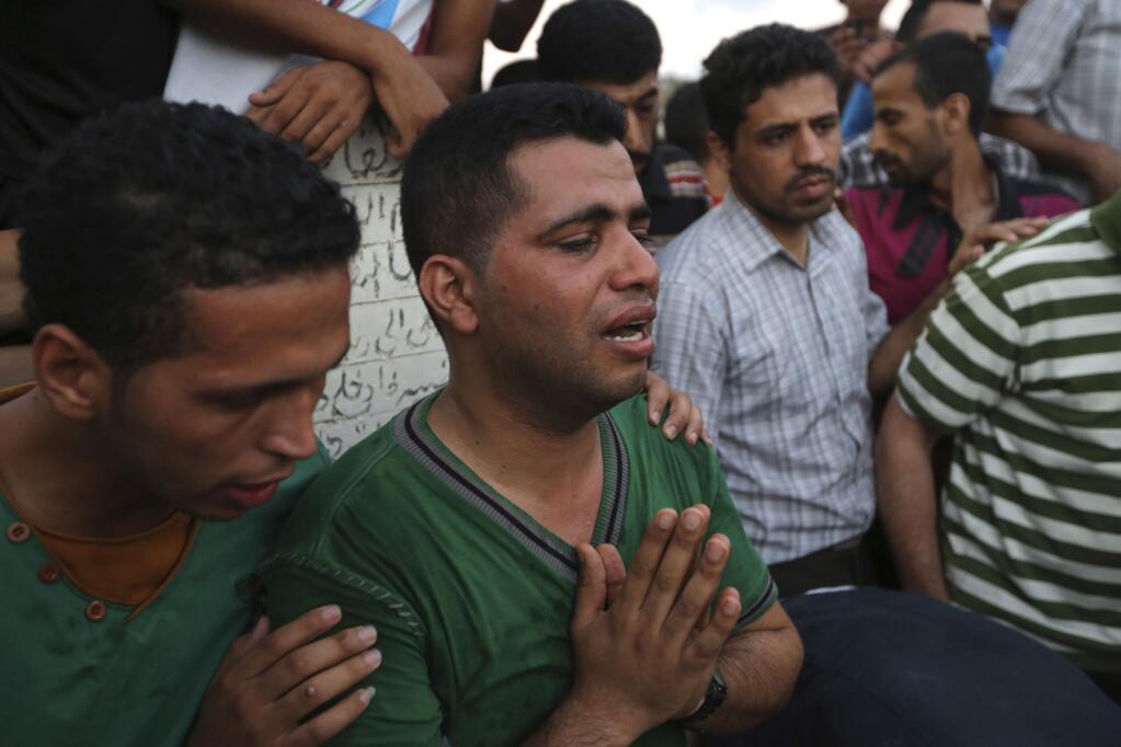 A Palestinian cries during the funeral of three children, killed by an Israeli missile strike earlier, in Gaza City, Thursday, July 17, 2014. The children were killed by an Israeli missile strike at their house feeding pigeons on their roof in the Sabra neighborhood of Gaza City, the family said. Fierce fighting between Israel and Hamas resumed Thursday, including an airstrike that killed three Palestinian children feeding pigeons on their roof, after a temporary cease-fire that allowed Gazans to stock up on supplies. (AP Photo/Hatem Moussa)