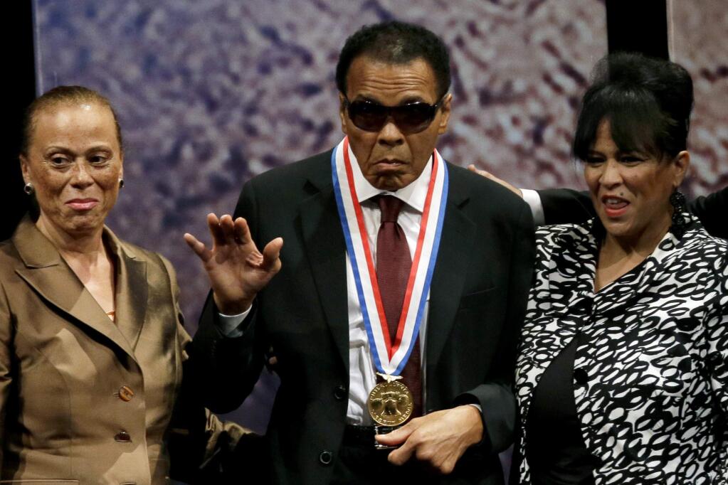 In this Sept. 13, 2012, file photo, Muhammad Ali, waves alongside his wife Lonnie Ali, left, and his sister-in-law Marilyn Williams, right, after receiving the Liberty Medal during a ceremony at the National Constitution Center in Philadelphia. (AP Photo/Matt Slocum, File)