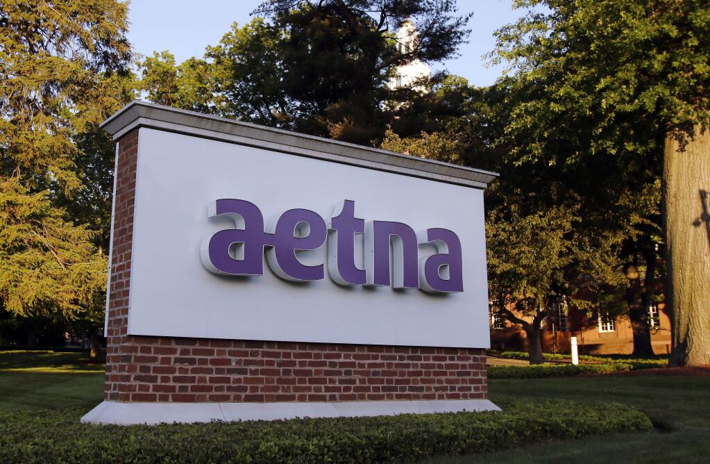 FILE - In this June 1, 2017, file photo, a sign stands on the campus of the Aetna headquarters, in Hartford, Conn. CVS will buy insurance giant Aetna in a roughly $69 billion deal that will help the drugstore chain provide more health care and keep a key client, according to a person with knowledge of the matter. (AP Photo/Bill Sikes, File)