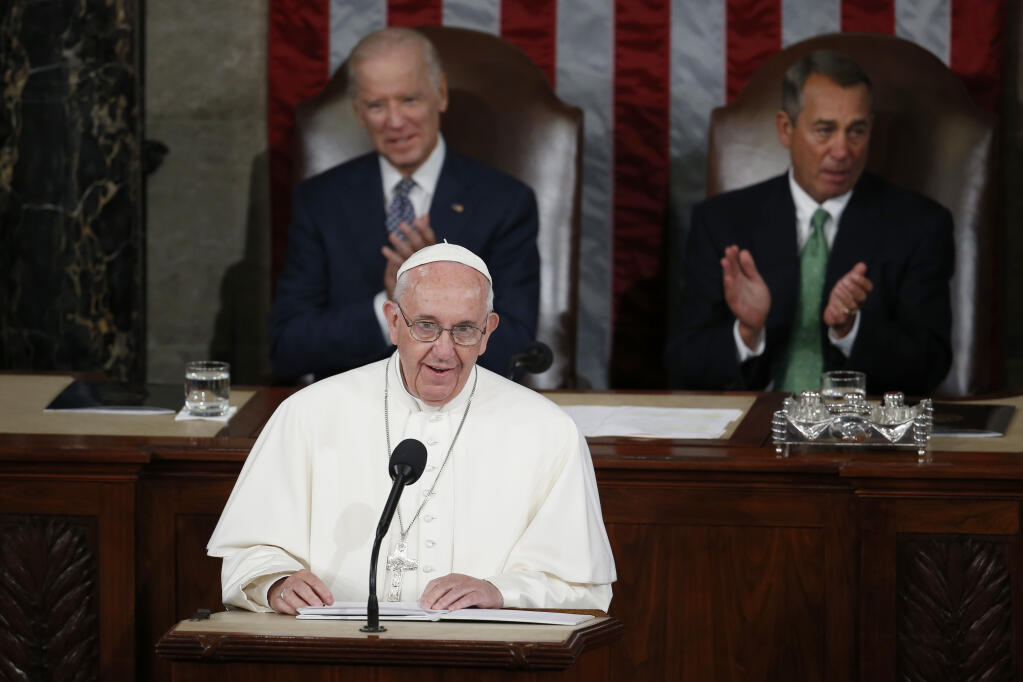 FILE - In this Thursday, Sept. 24, 2015 file photo, Pope Francis addresses a joint meeting of Congress on Capitol Hill in Washington, making history as the first pontiff to do so. Listening behind the pope are Vice President Joe Biden and House Speaker John Boehner of Ohio. President-elect Joe Biden, a lifelong Roman Catholic, spoke to Pope Francis on Thursday, Nov. 12, 2020, despite President Donald Trump refusing to concede. Trump claims — without evidence — that the election was stolen from him through massive but unspecified acts of fraud. (AP Photo/Carolyn Kaster)
