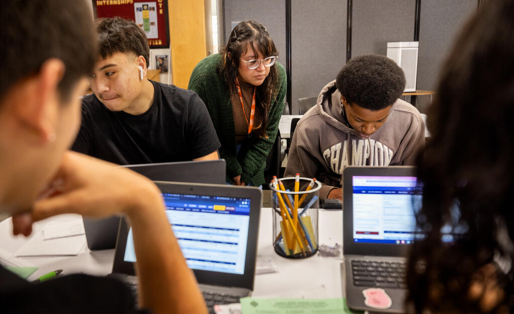 Elisabeth Cruz, center, a fellow with 10,000 Degrees, helps seniors Kel Zephirin, right, and Emilio Locke file FAFSA forms in the College and Career Counseling Center at Piner High School, Thursday, May 2, 2024, in Santa Rosa. (John Burgess / The Press Democrat)