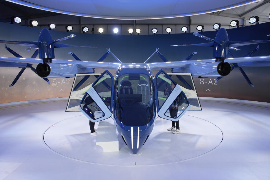 A person looks at the Supernal S-A2 passenger electric VOTL aircraft at the Supernal booth during the CES tech show Wednesday, Jan. 10, 2024, in Las Vegas. Supernal is a part of the Hyundai Motor Group. (AP Photo/John Locher)