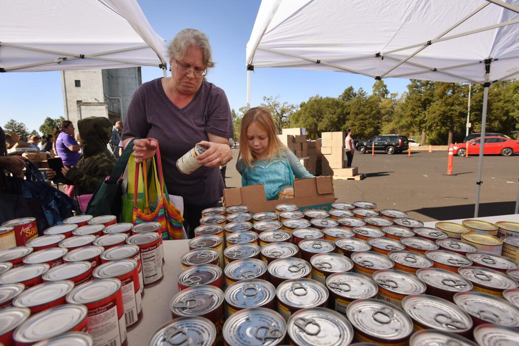 'We were camped out at Goat Rock for three nights, and it was freezing,' said Nicole La Rochelle of Monte Rio, who was collecting donated food for herself, and for her friend's daughter Aiona Lewis, 6, right, Friday, Nov. 1, 2019, at the Santa Rosa Fire Department Training Tower. (Erik Castro/for The Press Democrat)