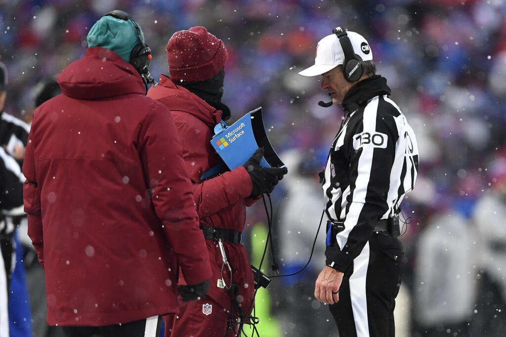 FILE - Referee Land Clark reviews a play during the second half of an NFL football game between the Buffalo Bills and the Atlanta Falcons in Orchard Park, N.Y., Jan. 2, 2022. The Indianapolis Colts are proposing a rule change that would allow for challenges of penalty calls in the last two minutes of the half. The NFL released a list of several rule change proposals Wednesday, March 13, made by teams. (AP Photo/Adrian Kraus, File)