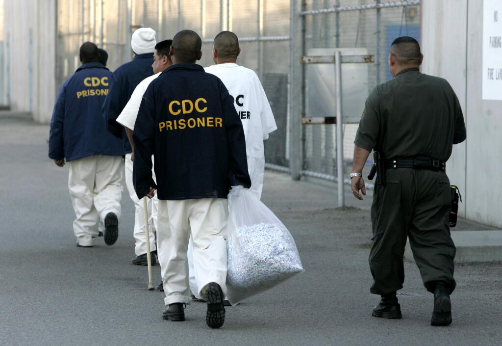 FILE - In this Jan. 14, 2009 file photo newly arrived inmates are escorted into the California State Prison, Corcoran, in Corcoran, Calif. California prison officials have halted an experiment aimed at trying to force warning prison gangs to get along with each other. Officials tell The Associated Press the temporary halt came after the inmates wound up brawling and even rioting after they were allowed to mingle together in prison recreation yards. The effort started more than a year ago with officials allowing prisoners from the different gangs into exercise yards to try to get them to interact and make peace.(AP Photo/Rich Pedroncelli, File )
