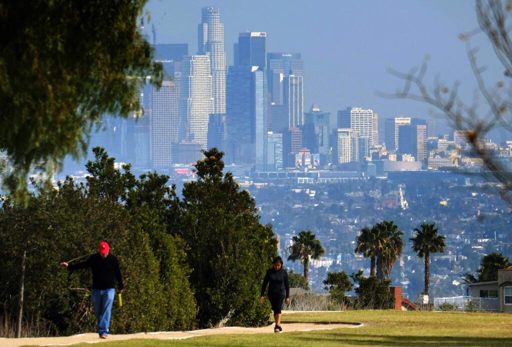 Hikers walk along a path at the Kenneth Hahn State Recreation Area near downtown Los Angeles on Sunday, Jan. 3, 2016. Southern California is bracing for a series of storms expected to begin late Sunday that could last all week. (AP Photo/Richard Vogel)