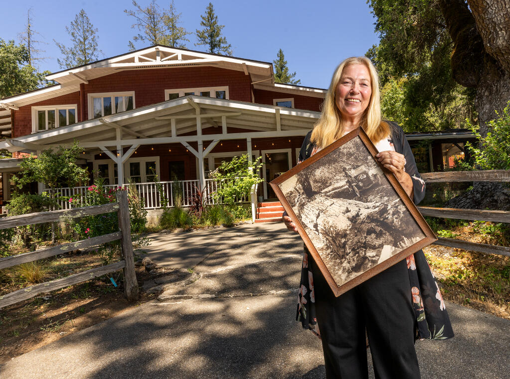 Janet Angell and her family are selling the Petrified Forest, a 500-acre property with the world’s largest petrified trees, for $12 million. Angell holds a photo of the first car to visit the Petrified Forest, in 1911, located between Santa Rosa and Calistoga, Wednesday, July 25, 2023. (John Burgess / The Press Democrat)