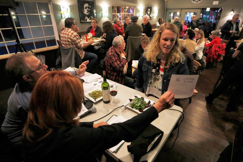 Madelyn Carter, who is visiting from San Antonio, Texas with her family, double checks her answer sheet with trivia night hosts Susan and Ken Kaplan, during trivia night at Murphy's Irish Pub and Restaurant in Sonoma on Wednesday, May 15, 2019. (ALVIN JORNADA /PD)