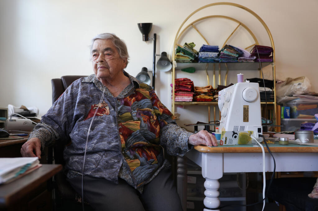 Catherine de la Cruz is connected to oxygen in her apartment in Santa Rosa on Thursday, Oct. 13, 2022.  While she has had asthma her entire life, the Tubbs Fire and other local wildfires since then have exacerbated her respiratory problems.  (Christopher Chung/The Press Democrat)