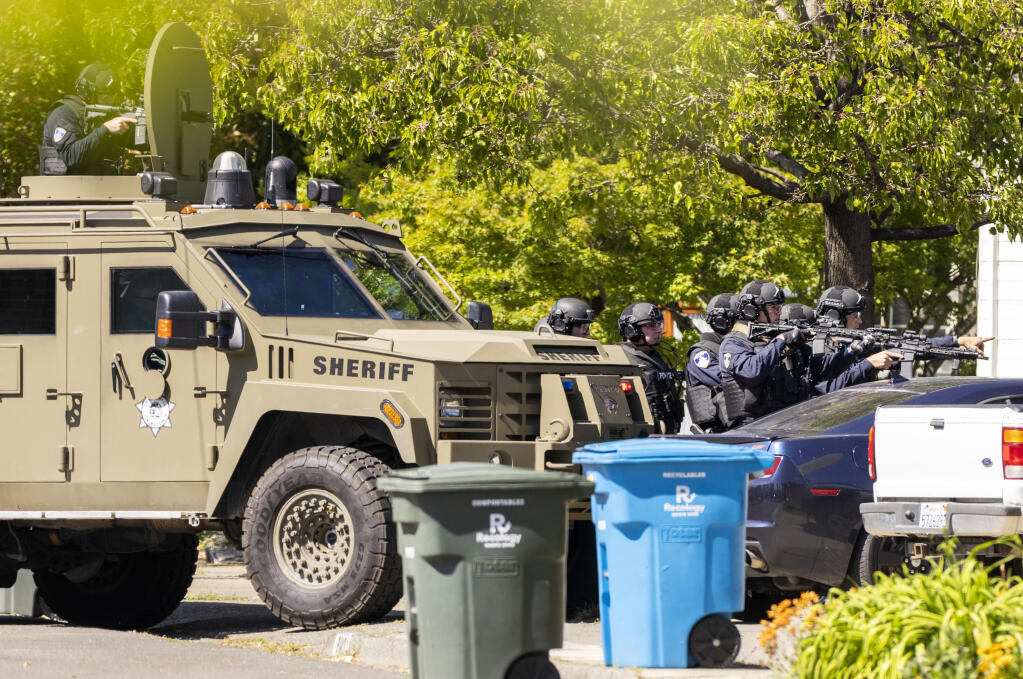 The Santa Rosa police department SWAT team moves in to enter a Humboldt. St. home on Wednesday afternoon, May 4, 2022 in search of a suspect, who was not home at the time.   (John Burgess/The Press Democrat)
