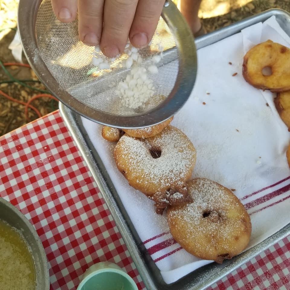 Apple Fritters being dusted with powdered sugar at the Gravenstein Apple Fair. (Clark Wolf).