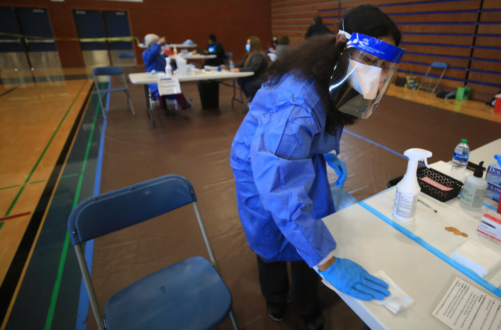 Sonoma County Health Officer Sundari Mase, Saturday, March 6, 2021, disinfects between patients as she volunteers at West County Health Center's vaccine clinic at Analy High School in Sebastopol. (Kent Porter / The Press Democrat) 2021
