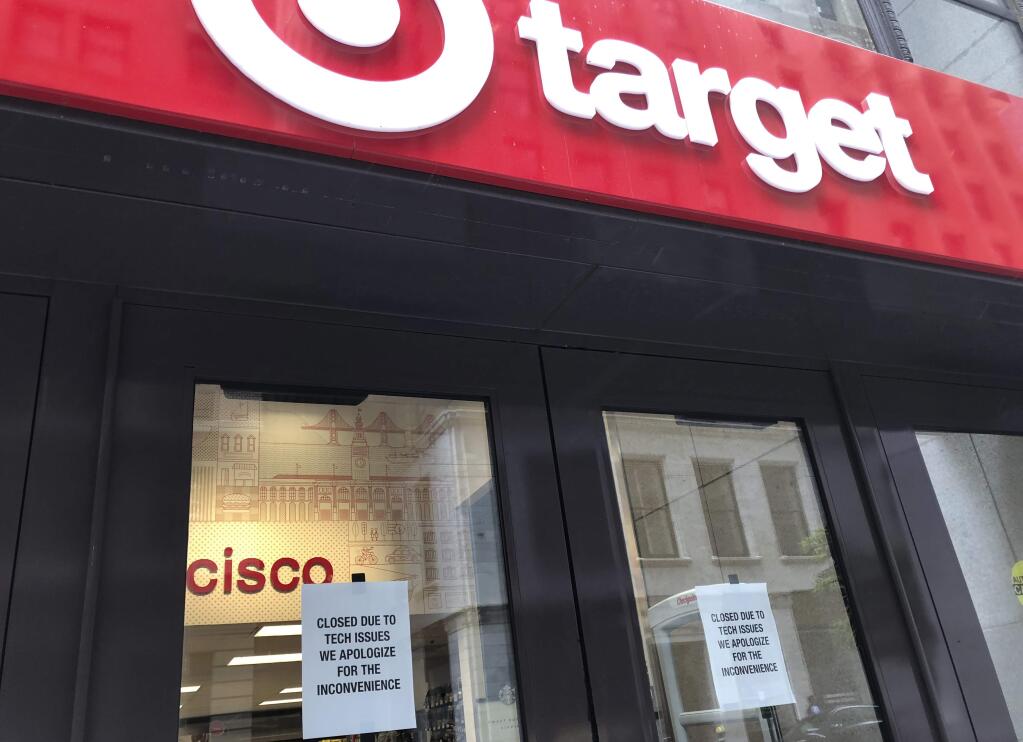 A sign is posted explaining a technical glitch at a Target store in San Francisco on Saturday, June 15, 2019. The technological glitch that stalled checkout lines at its stores worldwide, exasperating shoppers and eating into sales at a prime time for retailers. The outage periodically prevented Target's cashiers from scanning merchandise or processing transactions. Self-checkout registers also weren't working at times, causing massive lines in some stores. (AP Photo/Michael Liedtke)