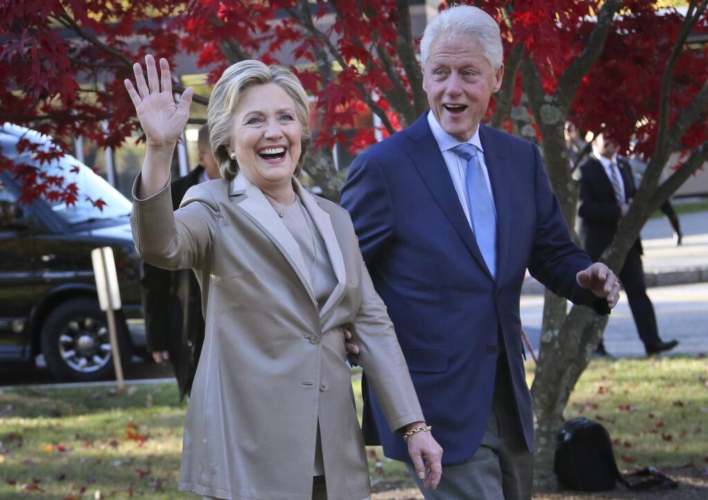 FILE - In this Nov. 8, 2016, file photo, Democratic presidential candidate Hillary Clinton, and her husband former President Bill Clinton, greet supporters after voting in Chappaqua, N.Y. The Clintons announced Monday, Oct. 8, 2018, they will visit four cities in 2018 and nine in 2019 across North America in a series of conversations dubbed “An Evening with President Bill Clinton and former Secretary of State Hillary Rodham Clinton.' (AP Photo/Seth Wenig, File)