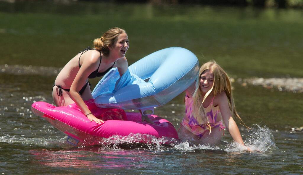MacKenzie Stratton, 15, left, and Jaleah Baumgarten, 11, of Rohnert Park fight their way back upstream through the rapids at the Monte Rio beach on the Russian River on Thursday, June 7, 2018. (photo by John Burgess/The Press Democrat)