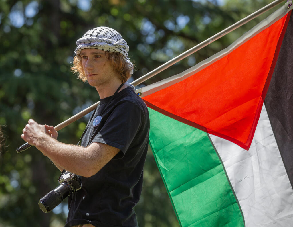 Santa Rosa Junior College student Julien Ducarroz carries a Palestinian flag after speaking during a rally and protest in support of Gaza at the Santa Rosa campus, Thursday, May 2, 2024. (Chad Surmick / The Press Democrat)