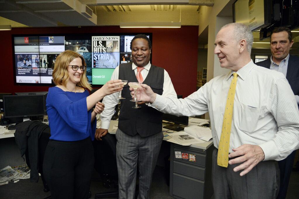 FILE - In this April 10, 2017, file photo, New York Daily News reporter Sarah Ryley, left, celebrates with News Editor Robert Moore, center, and Editor In Chief Arthur Browne in New York, after The New York Daily News and ProPublica won the 2017 Pulitzer Prize in public service. Newspaper publisher Tronc has acquired the Daily News, a storied New York tabloid newspaper that has been buffeted by the changing media environment, announced Monday, Sept. 4, 2017. (Jefferson Siegel/The Daily News via AP, File)