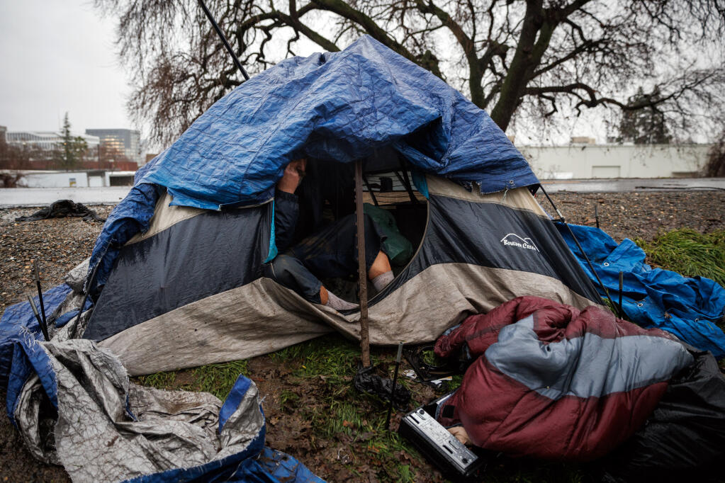 FILE — A camper above the American River in Sacramento, Calif., on Jan. 9, 2023. Californians voted last week on Proposition 1. If it passes, it would allocate money for treatment and supportive housing for homeless people with severe mental illnesses and substance use disorders. (Max Whittaker/The New York Times)