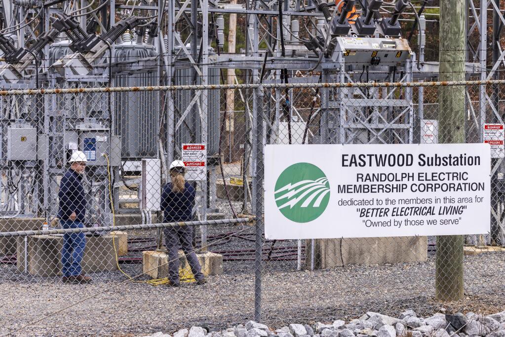 Workers with Randolph Electric Membership Corporation work to repair the Eastwood Substation in West End, N.C., Tuesday, Dec. 6, 2022. Two deliberate attacks on electrical substations in Moore County last Saturday evening caused days-long power outages for tens of thousands of customers. (Travis Long/The News & Observer via AP)