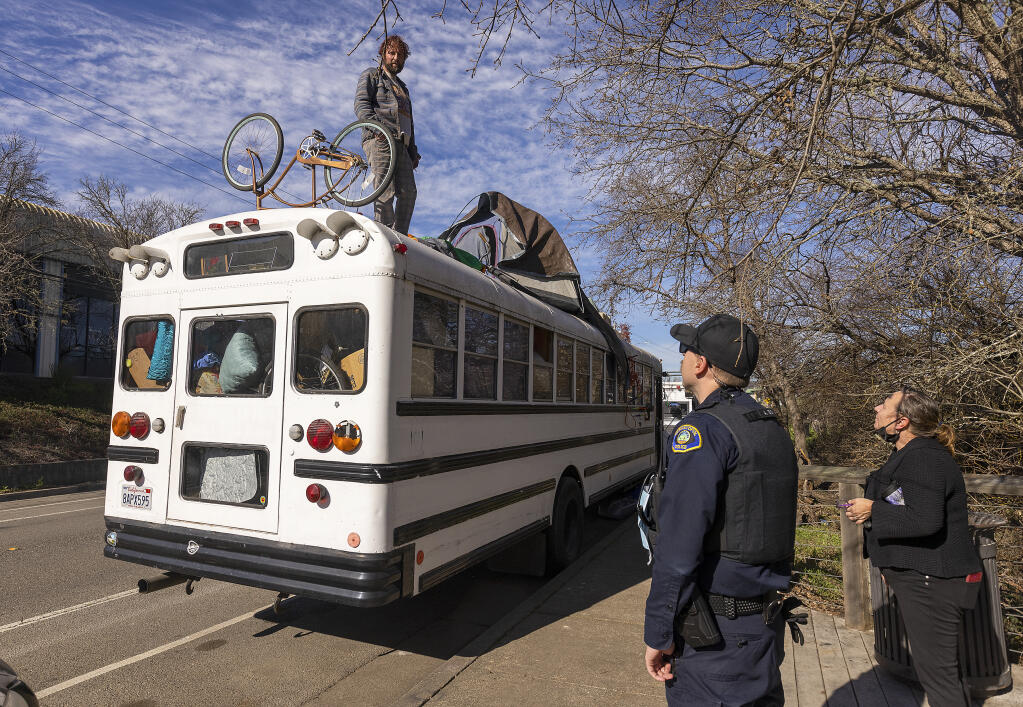Sebastopol police officer Endy, no first name given, asks J.D. Gadde, who has lived in his bus on Morris Street on and off for six years, to move his vehicle to another location on Thursday, Jan. 20, 2022. (John Burgess/The Press Democrat)