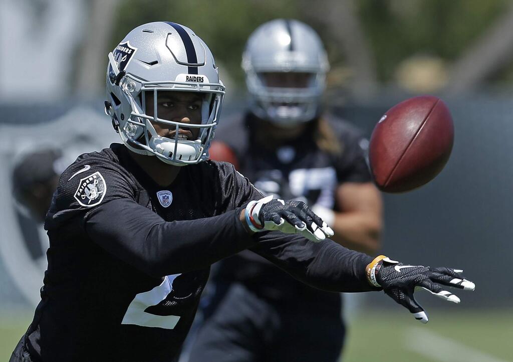 In this Tuesday, June 13, 2017 file photo, Oakland Raiders cornerback Gareon Conley tosses a ball during NFL football practice at the team's training facility in Alameda, Calif. Oakland Raiders first-round pick Gareon Conley passed his physical and has been taken off the physically unable to perform list. Conley took part in practice Tuesday, Aug. 29, 2017 for the first time since injuring his shin during minicamp on June 13. (AP Photo/Ben Margot, File)