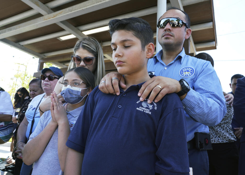 Omahar Padillo holds on to his son Omahar Jr., 12, during a community prayer Wednesday, May 25, 2022, in Pharr, Texas, for the shooting victims at Robb Elementary School in Uvalde, Texas. (Joel Martinez/The Monitor via AP)