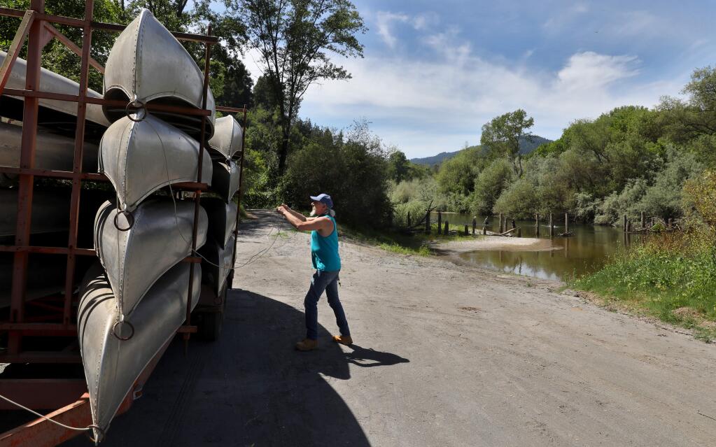 Burke's Canoe Trips worker Tony Harley brings a trailer of canoes down to the banks of the Russian River, in Forestville on Friday, June 5, 2020. (Christopher Chung/ The Press Democrat)