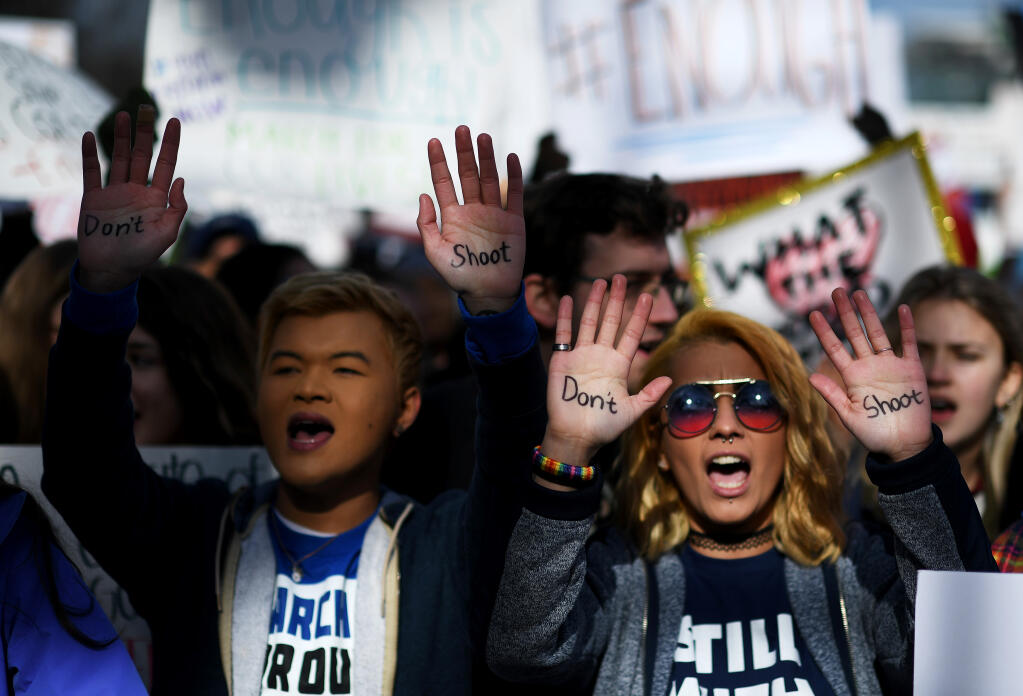 From left, Hunter Nguyen, 21, of Hagerstown, Md., and Daisy Hernandez, 22, of Stafford, Va., display “Don't shoot” on their hands at the March for Our Lives protest in Washington on March 24, 2018. (Washington Post photo by Matt McClain)