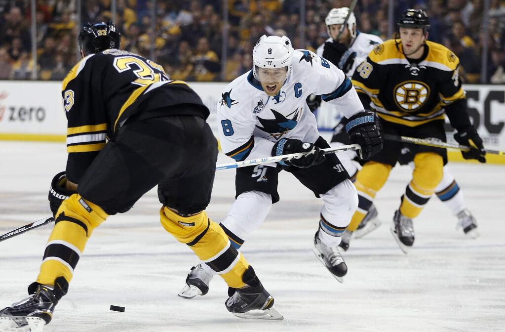 San Jose Sharks' Joe Pavelski (8) brings the puck up as Boston Bruins' Zdeno Chara (33) defends during the first period of an NHL hockey game in Boston, Tuesday, Nov. 17, 2015. (Photo/Michael Dwyer)