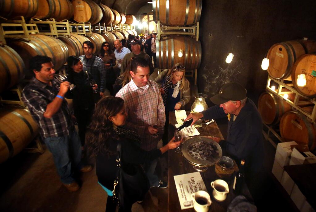 John Duddy serves wine in the caves at Bella Vineyards in the Dry Creek Valley during Wine Road Barrel Tasting in 2014. (The Press Democrat file)