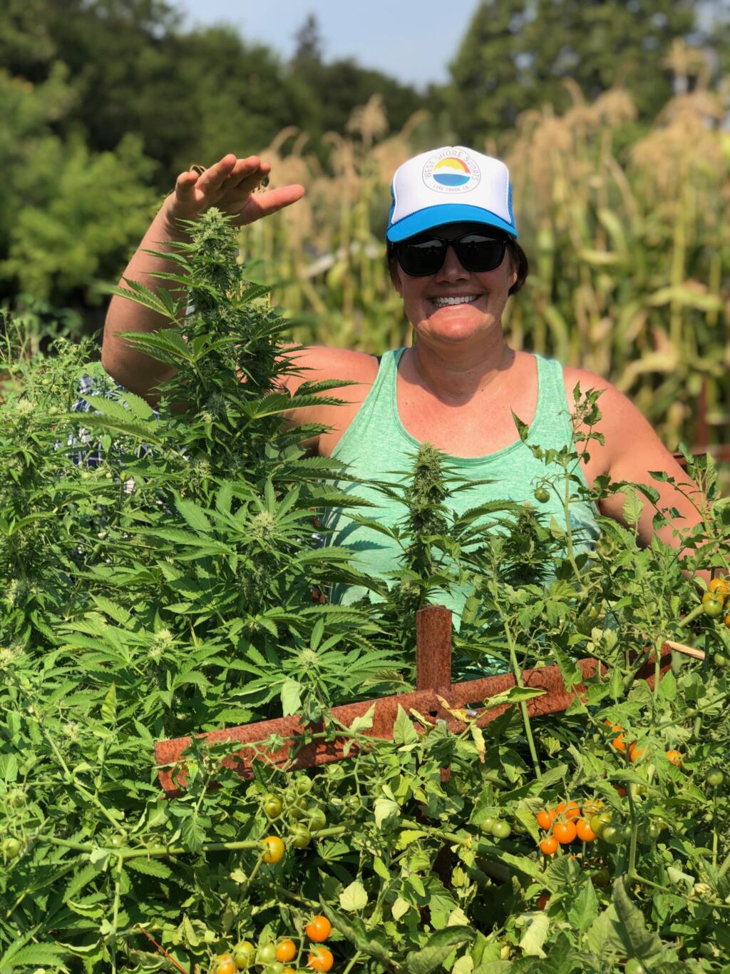 Erin Gore, founder and CEO, Garden Society, Cloverdale. She shows how high a cannabis plant is growing. (Courtesy: Erin Gore)