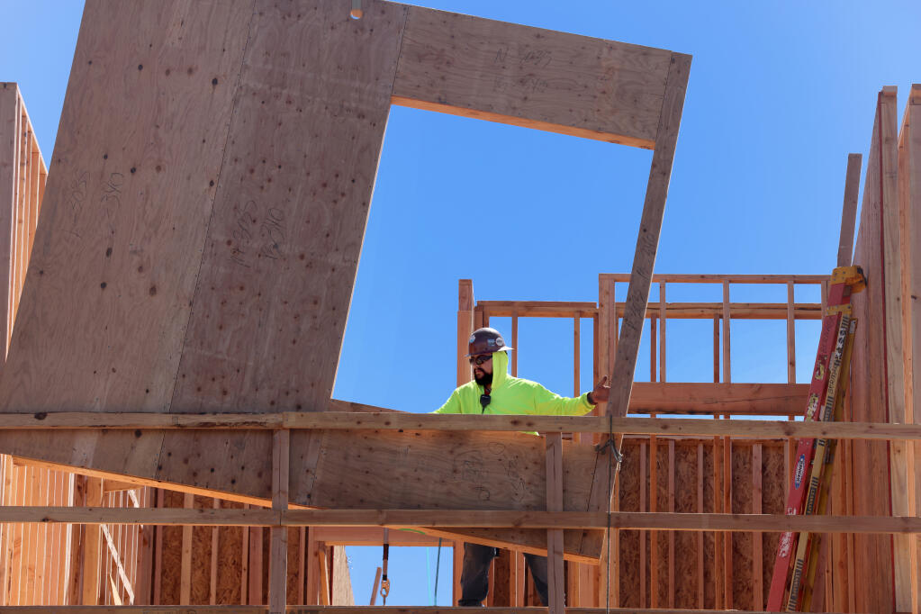 A construction worker from MHA RDR works on the framing for a new student housing complex at Napa Valley College in Napa, Tuesday, July 11, 2023. (Beth Schlanker / The Press Democrat)