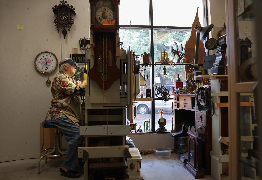 Clocksmith Cyrus Wind Dancer works on repairing a clock at his Rincon Valley shop in Santa Rosa, Friday, Aug. 4, 2023. Wind Dancer is closing his Santa Rosa shop and moving out of the area because of the high cost of living. (Christopher Chung / The Press Democrat)
