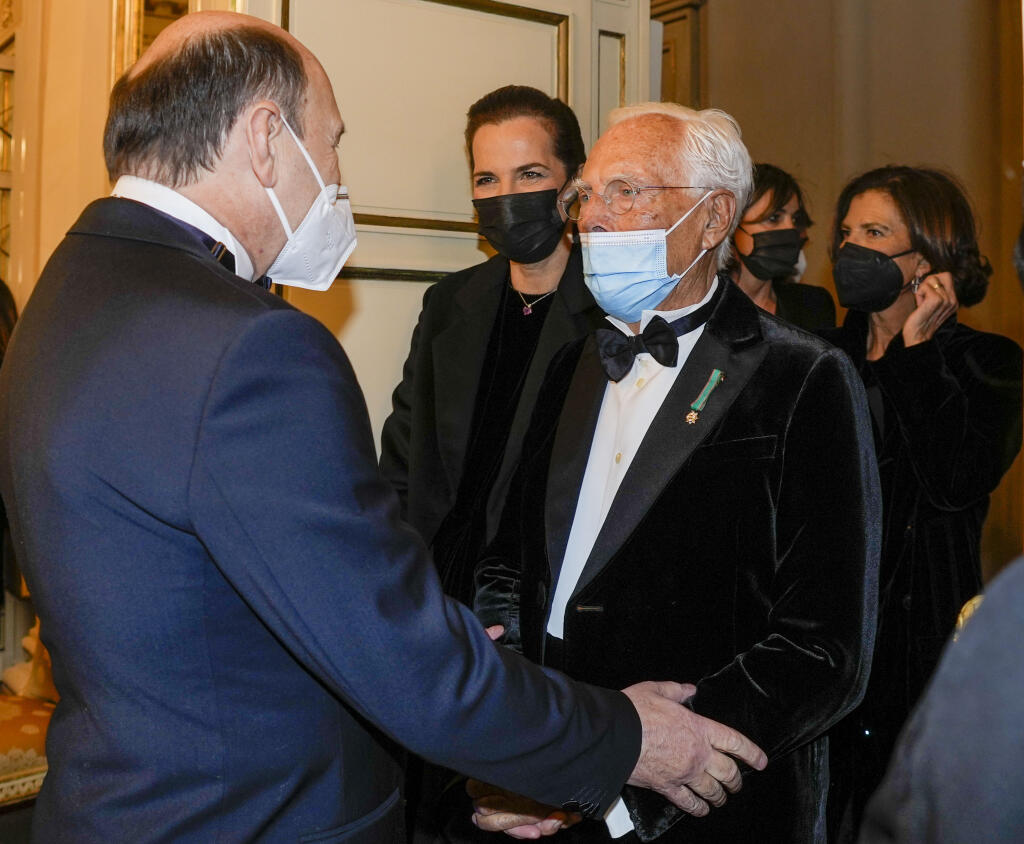 Fashion designer Giorgio Armani, right, is welcomed by La Scala Superintendent Dominique Meyer as he arrives for the premiere of Verdi's Macbeth at La Scala opera house in Milan, Italy, Tuesday, Dec. 7, 2021. The Macbeth opens the 2021/2021 lyric season of one of the most storied opera house in the world. (AP Photo/Antonio Calanni)